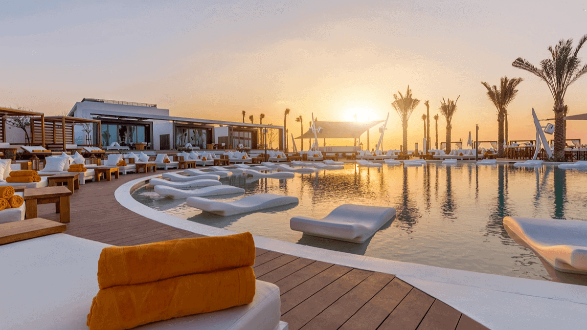 White daybeds around the pool at Nikki Beach Resort on Pearl Jumeira