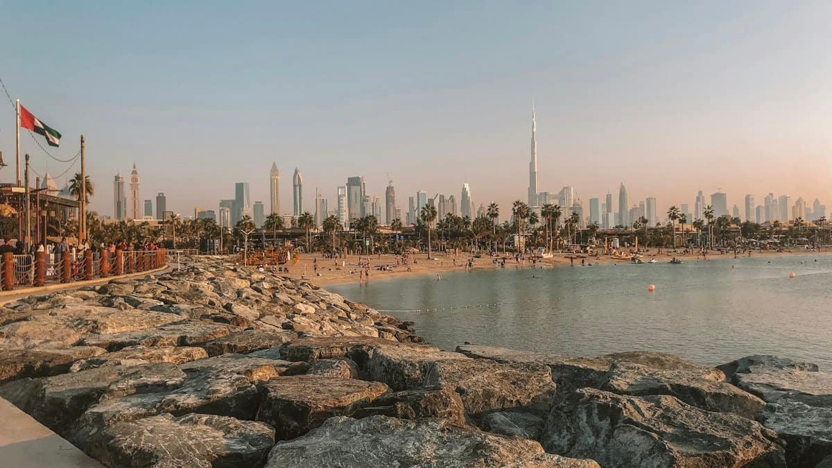 Calm water and a sandy Jumeirah beach with the Downtown Dubai skyline and Burj Khalifa on the horizon